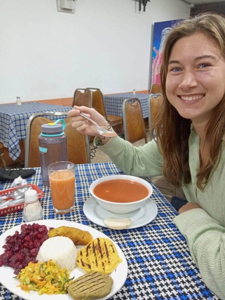 ik eet hier een tomatensoep met een vegetarische lunch die bestaat uit rijst, rode biet, een arepa en bonen