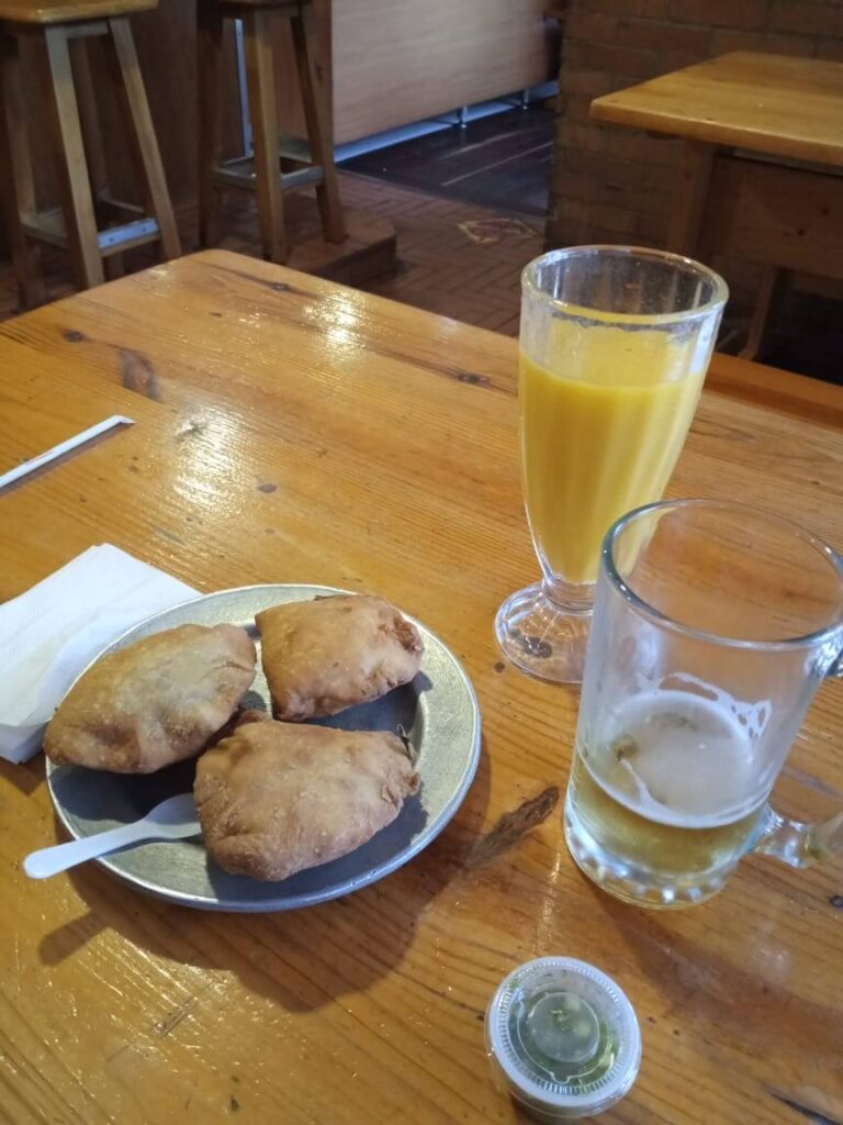 3 empanada's op een bord met daarnaast een vers sapje in een glas