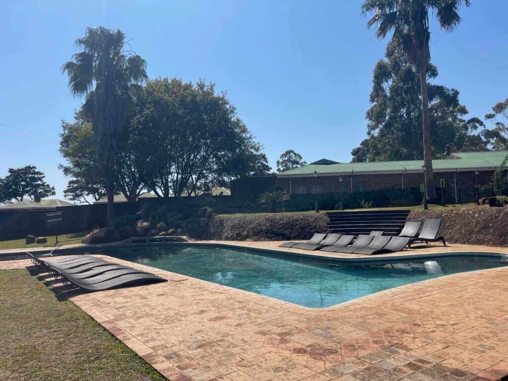 Het zwembad bij de lodge. Ernaast staan links en rechts lage grijze ligbedden