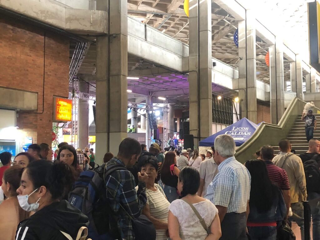 Een flinke groep mensen staat hier in het busstation