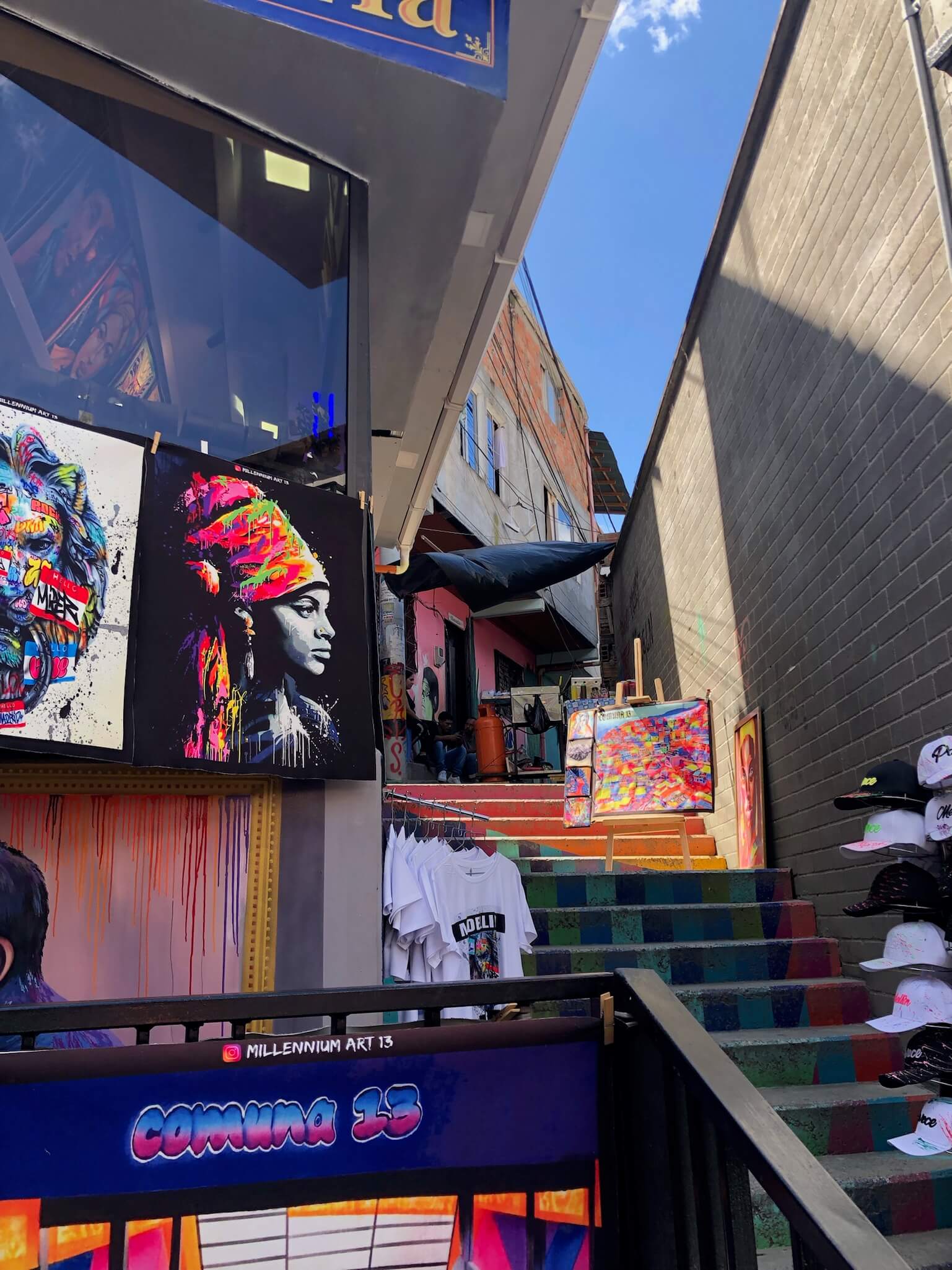 Deze foto is genomen in comuna 13. Rechts zie je een trap omhoog lopen en links zie je creatieve tekeningen aan de muren hangen