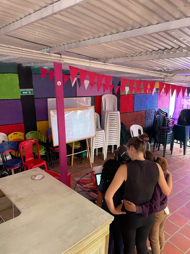 Ik heb m'n armen om 2 kleine meiden heengeslagen. We staan in een ruimte met roze tegels en rode vlaggetjes