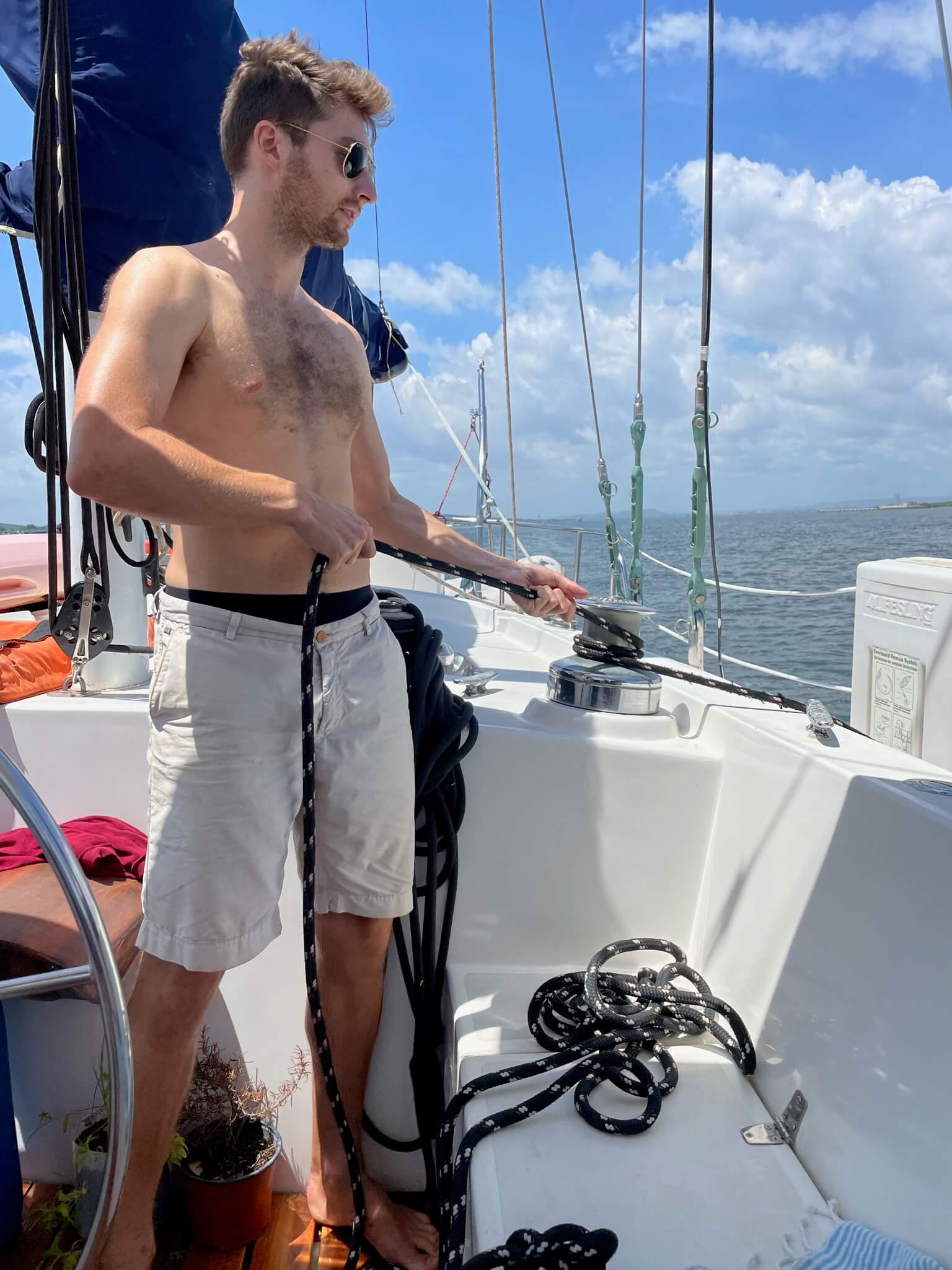 Niels staat op de zeilboot aan touwen te trekken