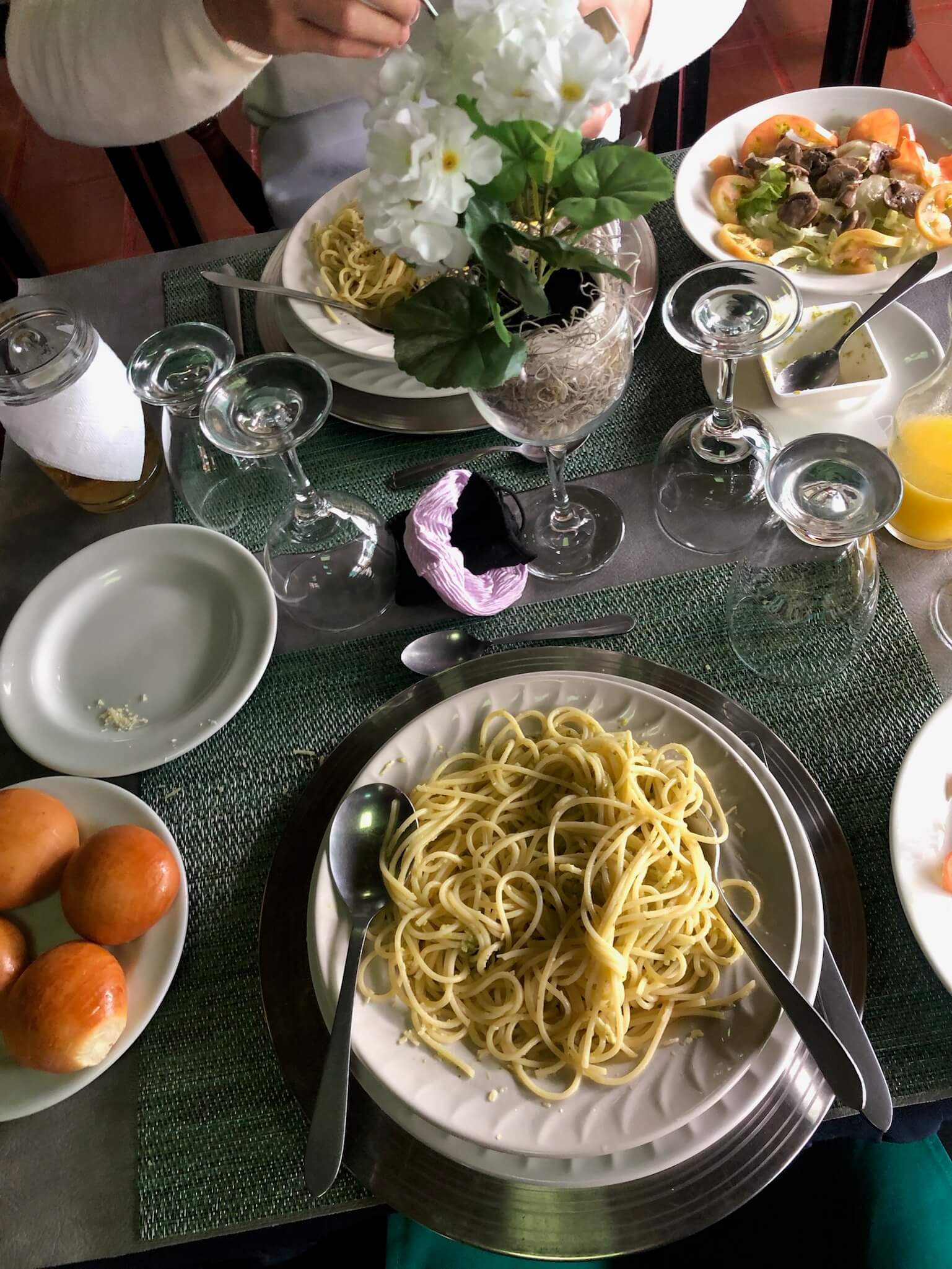 een foto van de eettafel met daarop een bord pasta en een bord met 4 kleine broodjes