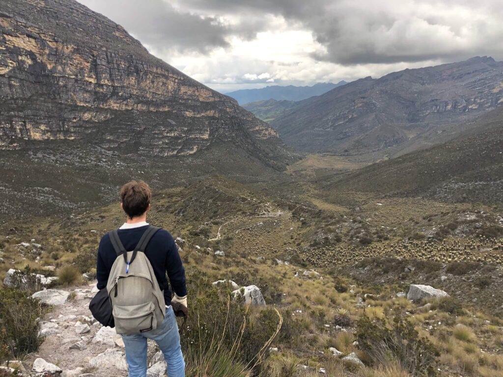niels staat van het uitzicht te genieten: een berg op links en een berg op rechts, met in het midden een soort vallei. Er hangt een donkere wolk in de lucht