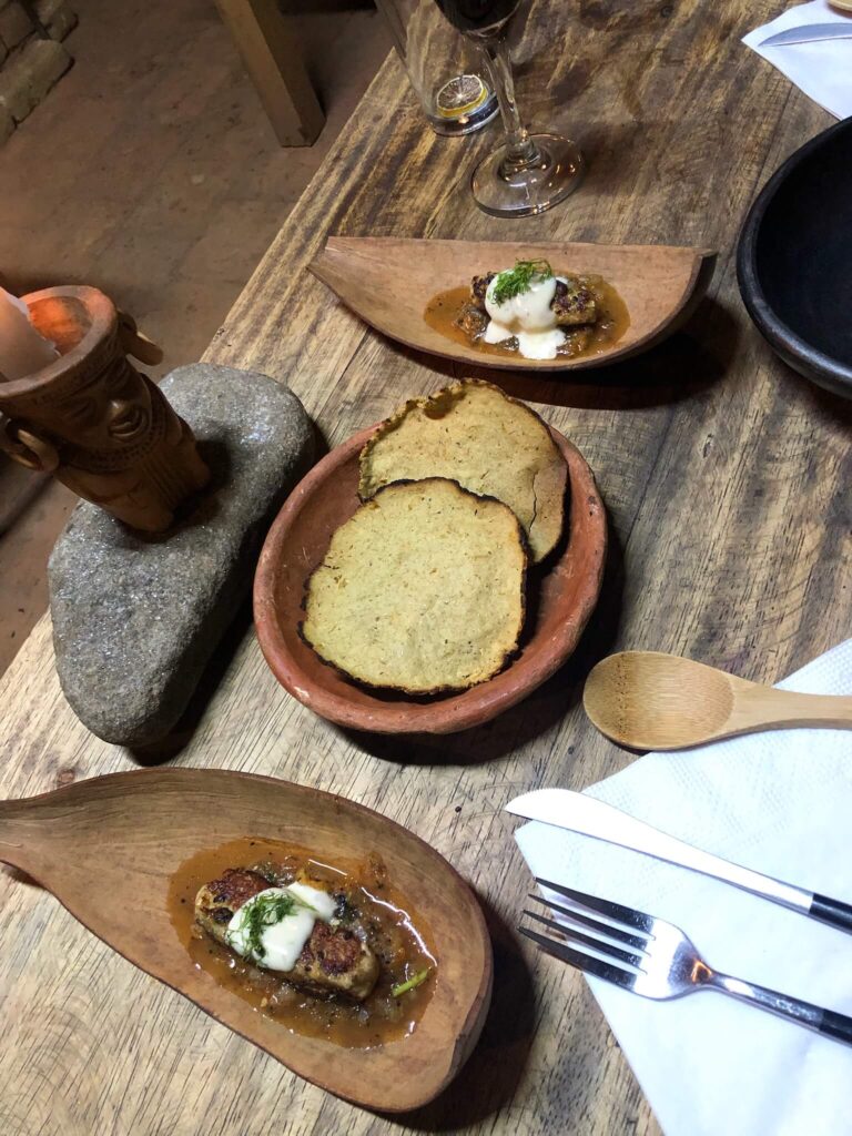 Een foto van een tafel waarop 3 kleine bordjes met culinair eten staan