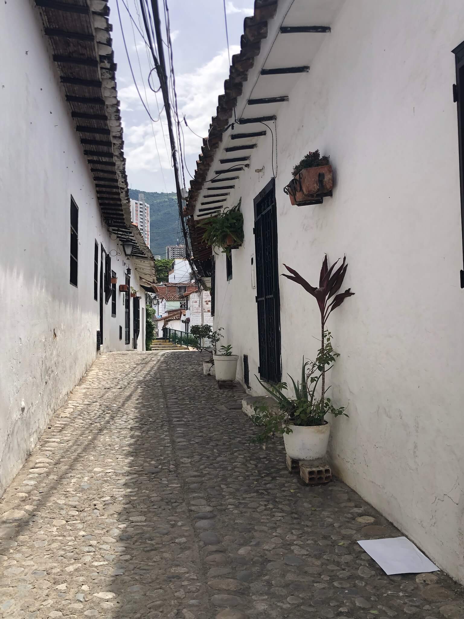 Een smal wandelstraatje in Giron met witte huisjes links en rechts