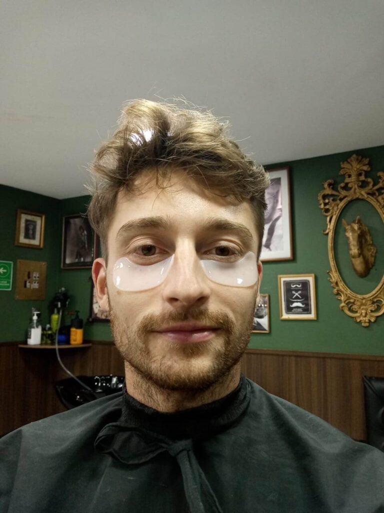 Een selfie van Niels bij de barbier. Hij heeft twee mini maskers op z'n wallen geplakt gekregen