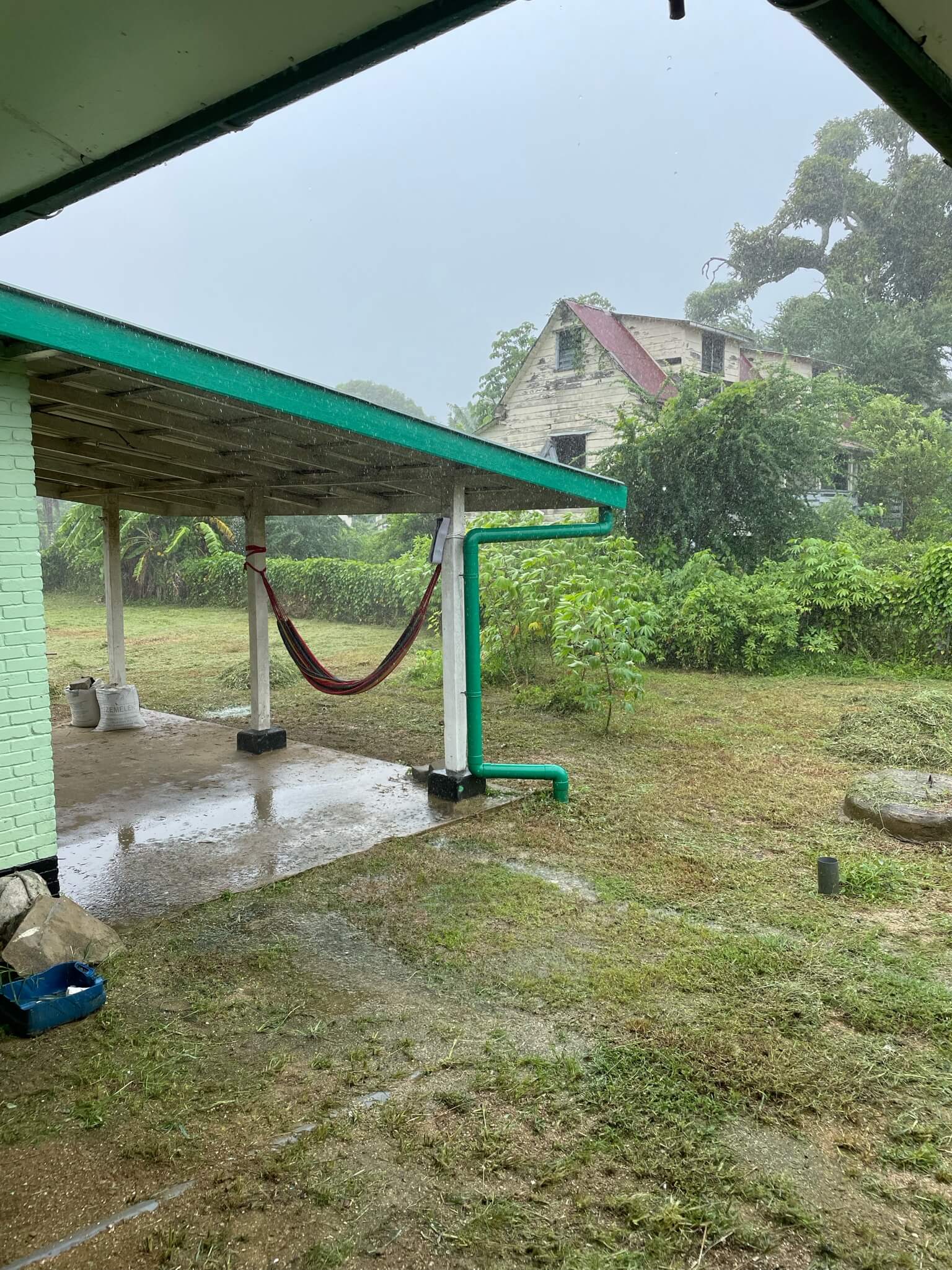 Een regenachtige dag. De lucht is grauw. Je ziet de hangmat hangen