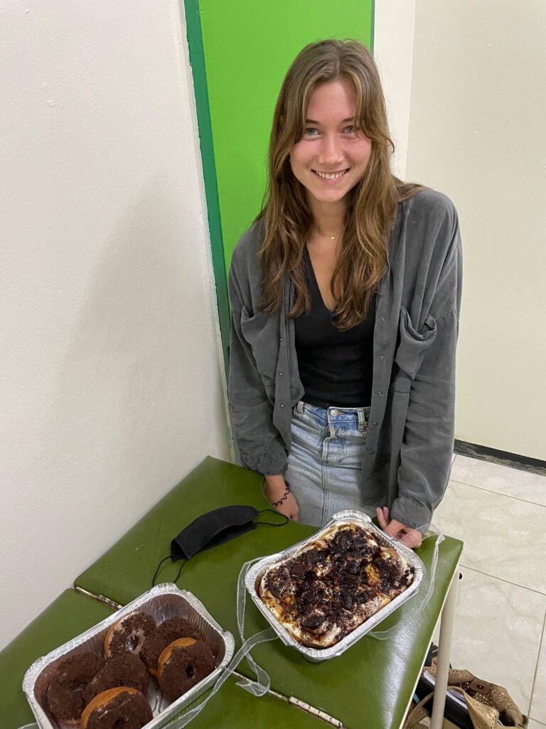 Ik sta achter een tafel en voor mij op tafel staan 2 schalen met elk een paar heerlijke donuts