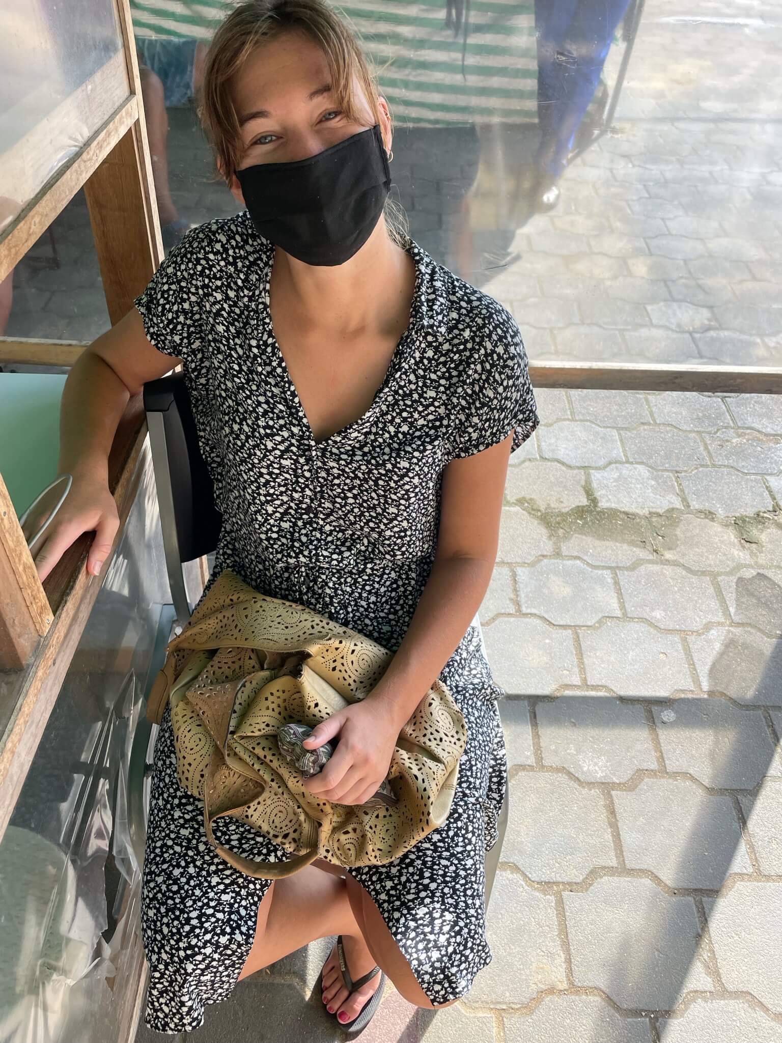 Ik zit aan een loket met een mondkapje op. Ik laat me hier testen op covid