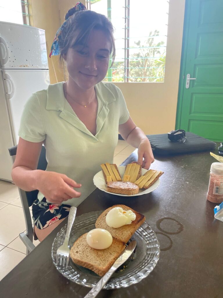 Ik zit aan tafel en voor mij staan 2 borden met eten: op de ene liggen crackers met kaas en op de ander boterhammen met ei