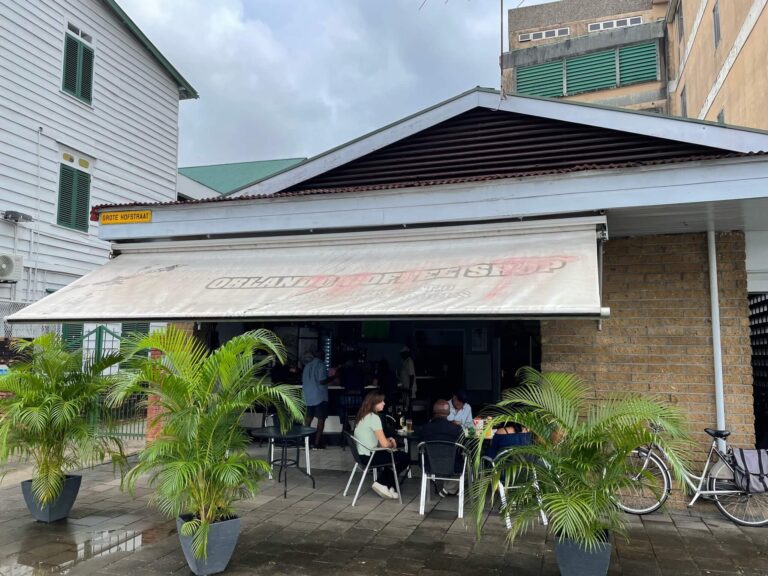 De buitenkant van het caféetje staat hier op de foto, waar je mij met de Surinamers aan een tafeltje ziet zitten