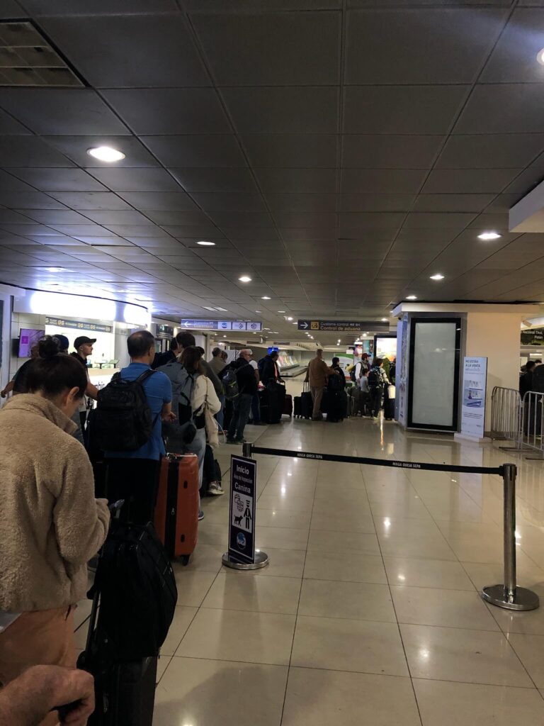 Je ziet hier een lange wachtrij op het vliegveld voor security