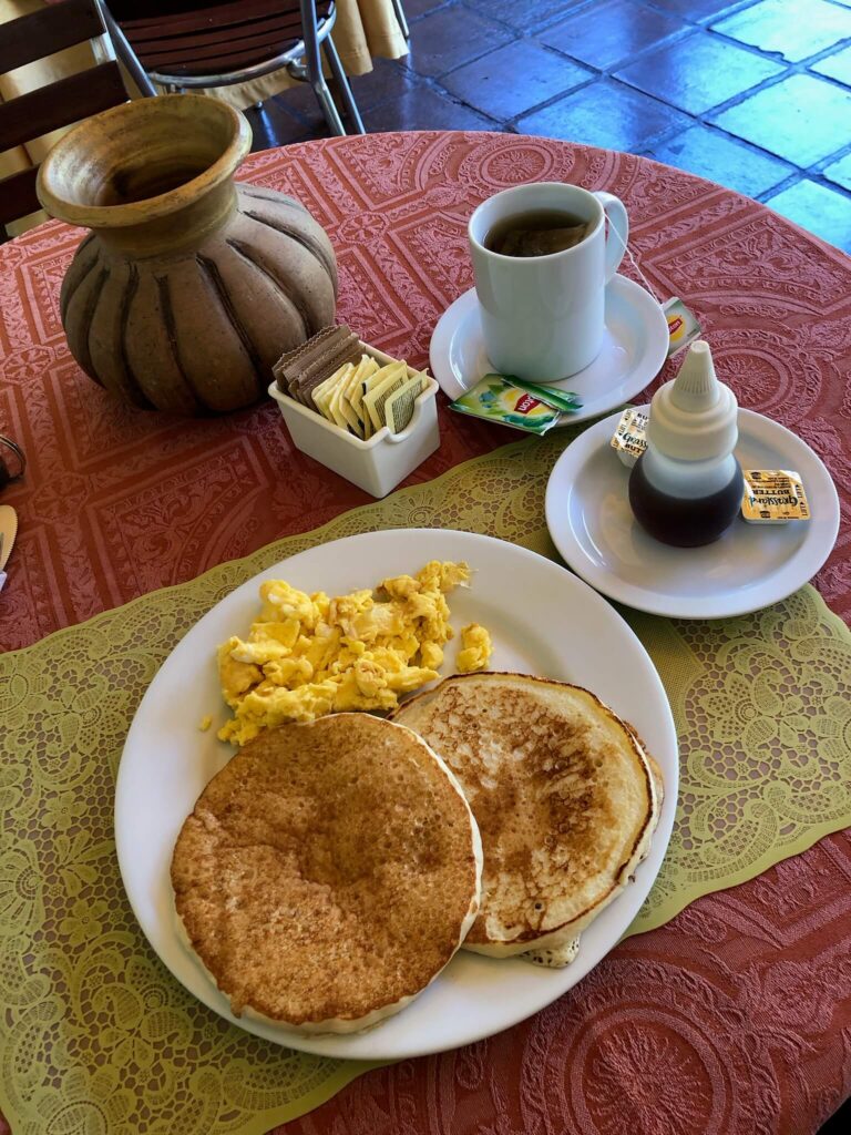 Een heerlijk ontbijt: vers gebakken pannenkoekjes met ei en een theetje