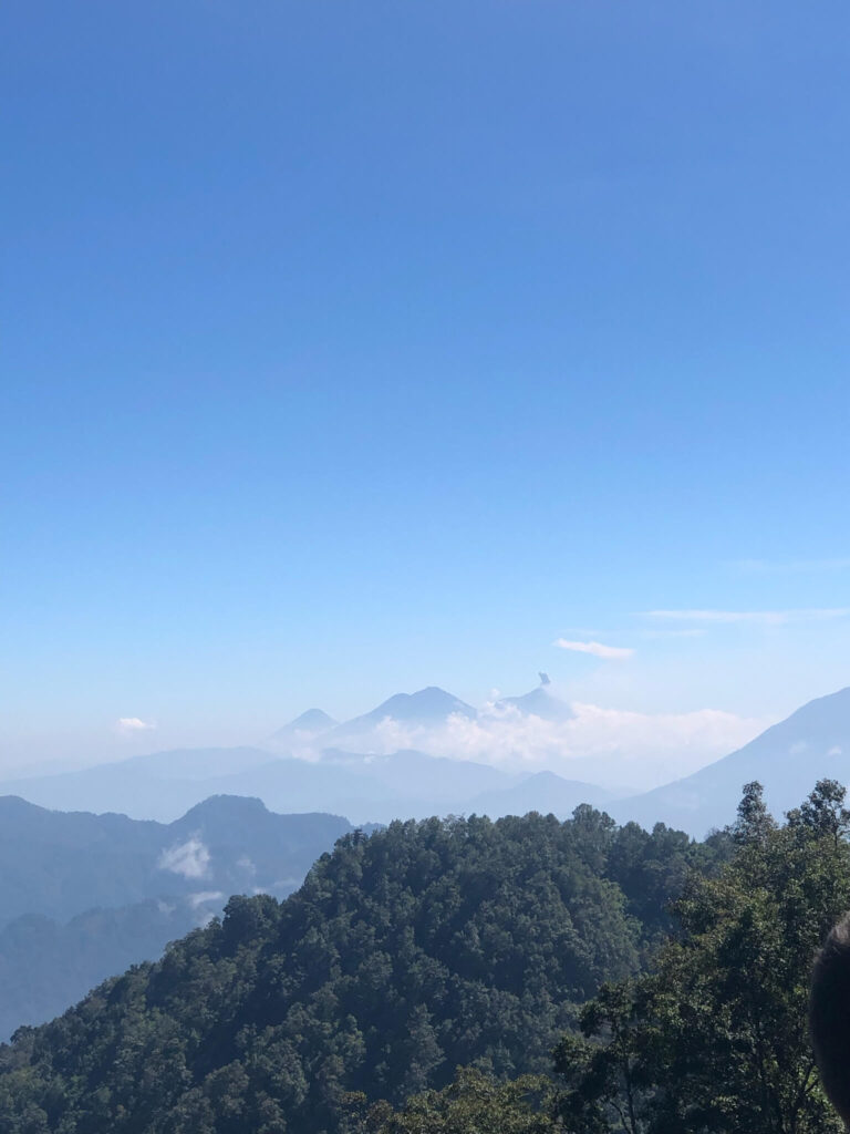 Uitzicht op de silhouetten van bergtoppen in de verte die zich deels in de wolken bevinden