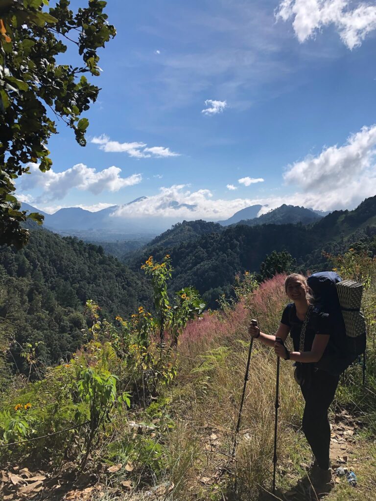 Ik sta poserend met m'n wandelstokken voor prachtige bergen. Wat een geweldig uitzicht!