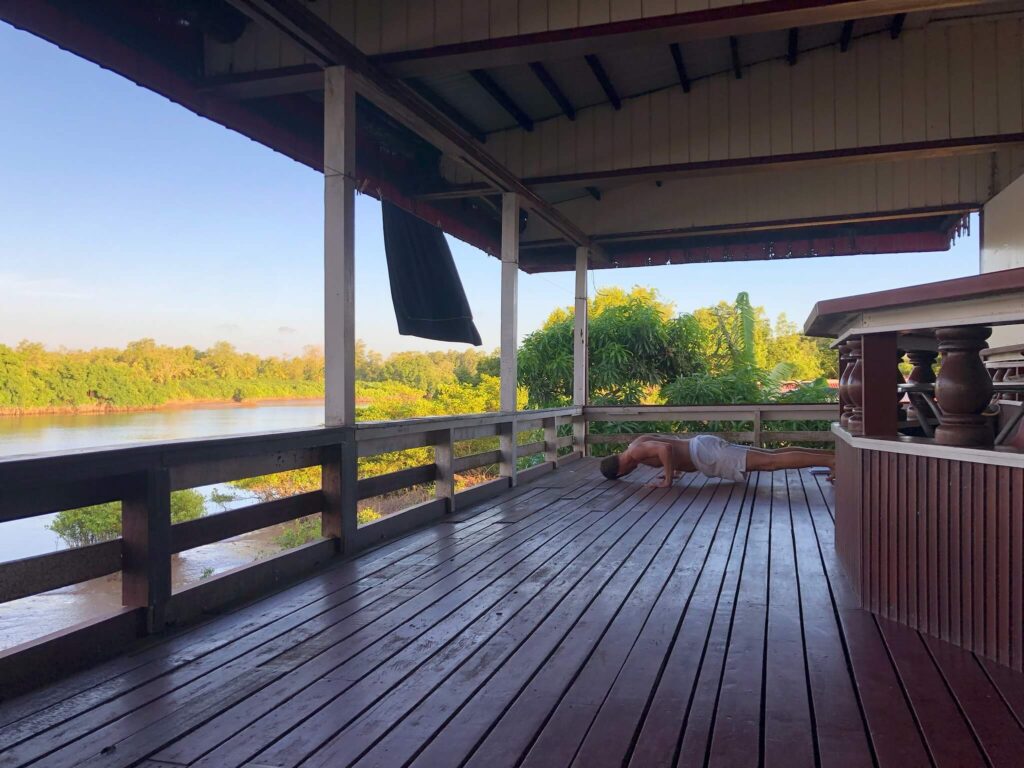 De veranda van Carla wat ons gedeelte is. Niels is achterin op de veranda een push-up aan het doen. Links van de veranda zie je in de verte de rivier