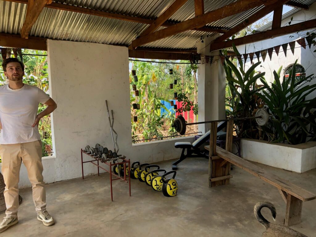 De 'sportschool': een bijgebouwtje in de tuin die je hier van de binnenkant ziet. Je ziet allerlei kettle bells liggen en een bench