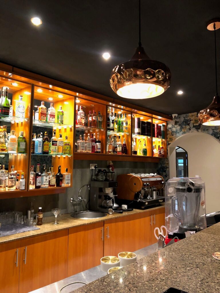 De gezellige houten bar bij Casa Mia, die volstaat met flessen drank