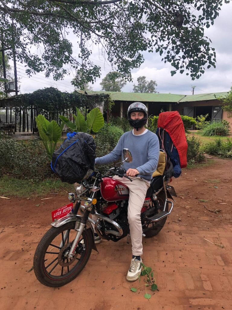 Niels zit op een volbepakte motor. Op de voor- en achterkant is bagage vastgebonden