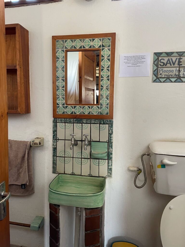 Prachtige handgemaakte tegels zitten achter de wasbak in de badkamer