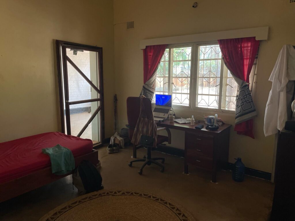 Onze eigen woonkamer in Malosa. Je ziet hier een bankje staan en een bureau met daarachter een bureaustoel