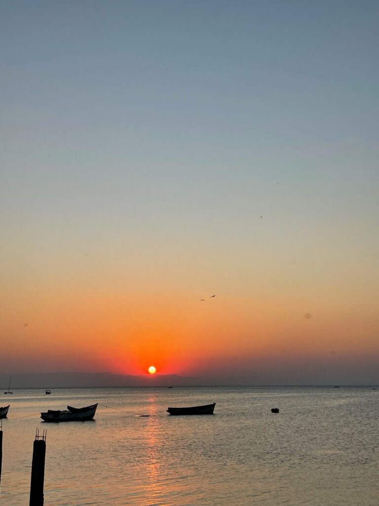 De zon zakt in het meer. De lucht is prachtig oranje/geel