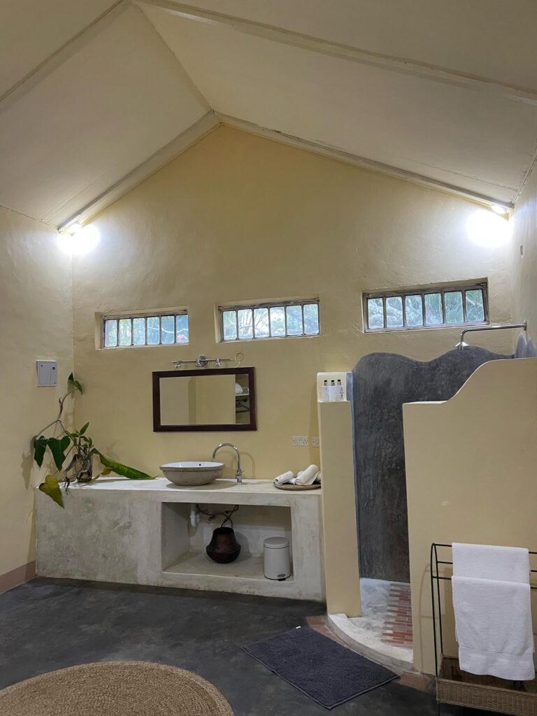 De mega ruime badkamer! De ruimte is hoog en geel geschilderd. Er is een ruime douche en ruime wasbak