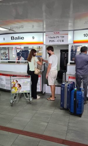 Niels en ik zijn vanaf de achterkant gefotografeerd. We staan bij de balie op het vliegveld om in te checken