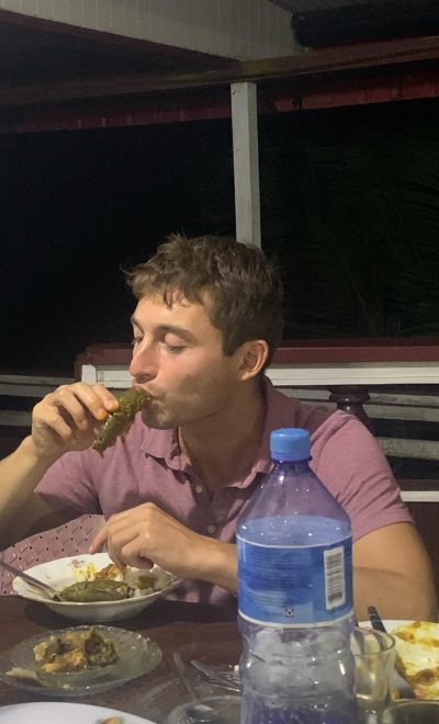 Niels zit aan tafel en stopt een vis in zijn mond